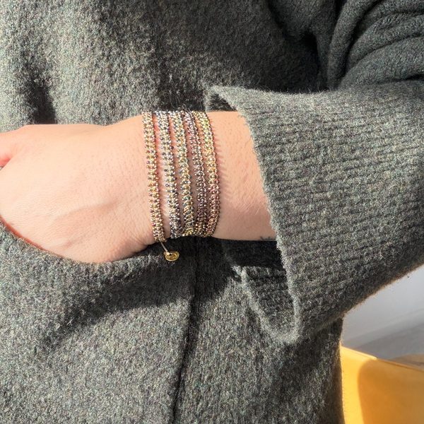 Close-up of stacked LeJu Glimmer bracelets worn on the wrist
