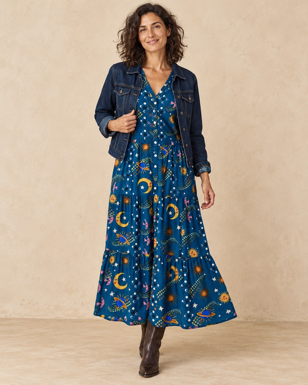 Model wearing the blue celestial print maxi dress with an open denim jacket and cowboy boots