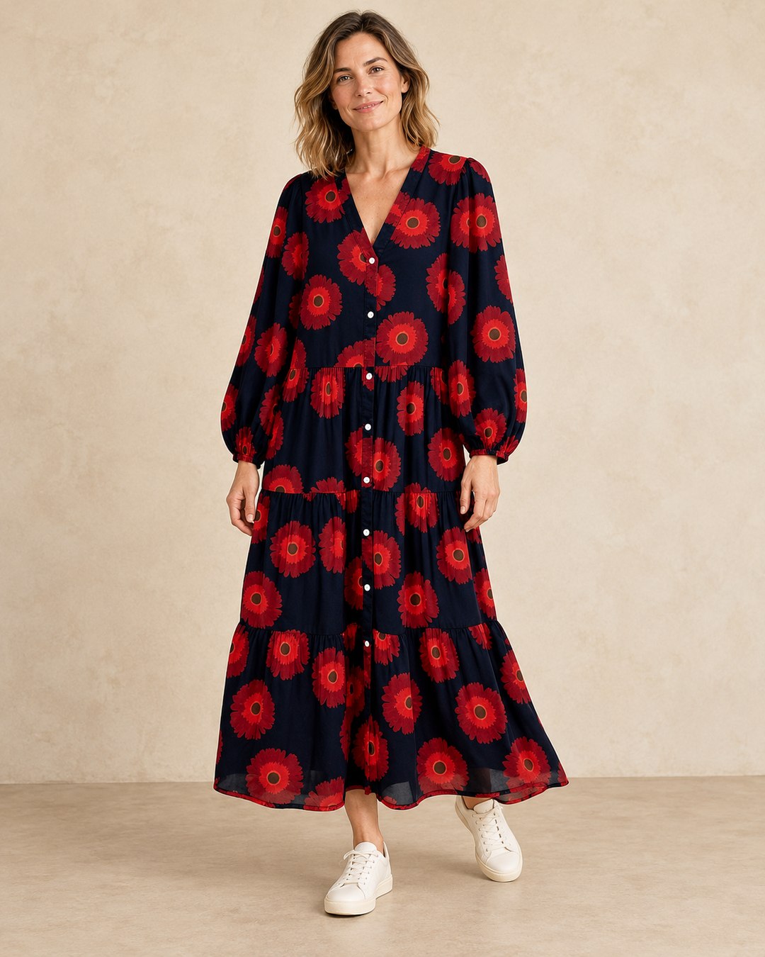 Model wearing the red floral maxi dress with leather trainers on a beige background