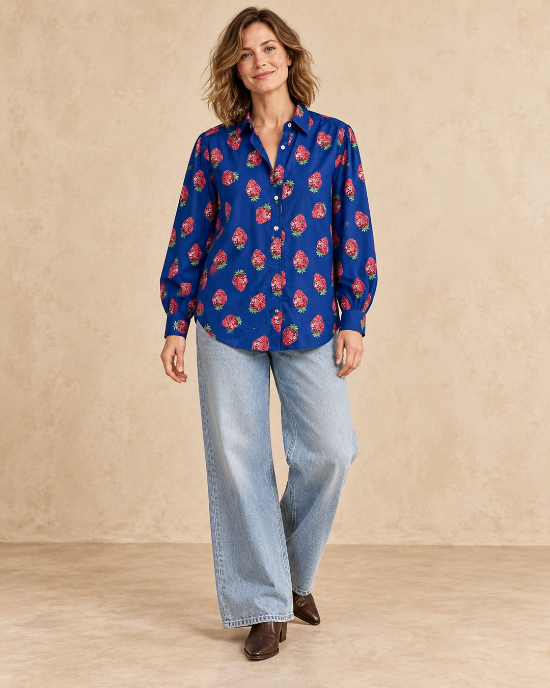 Model wearing Strawberry Disco Shirt untucked with wide light-wash jeans and leather boots