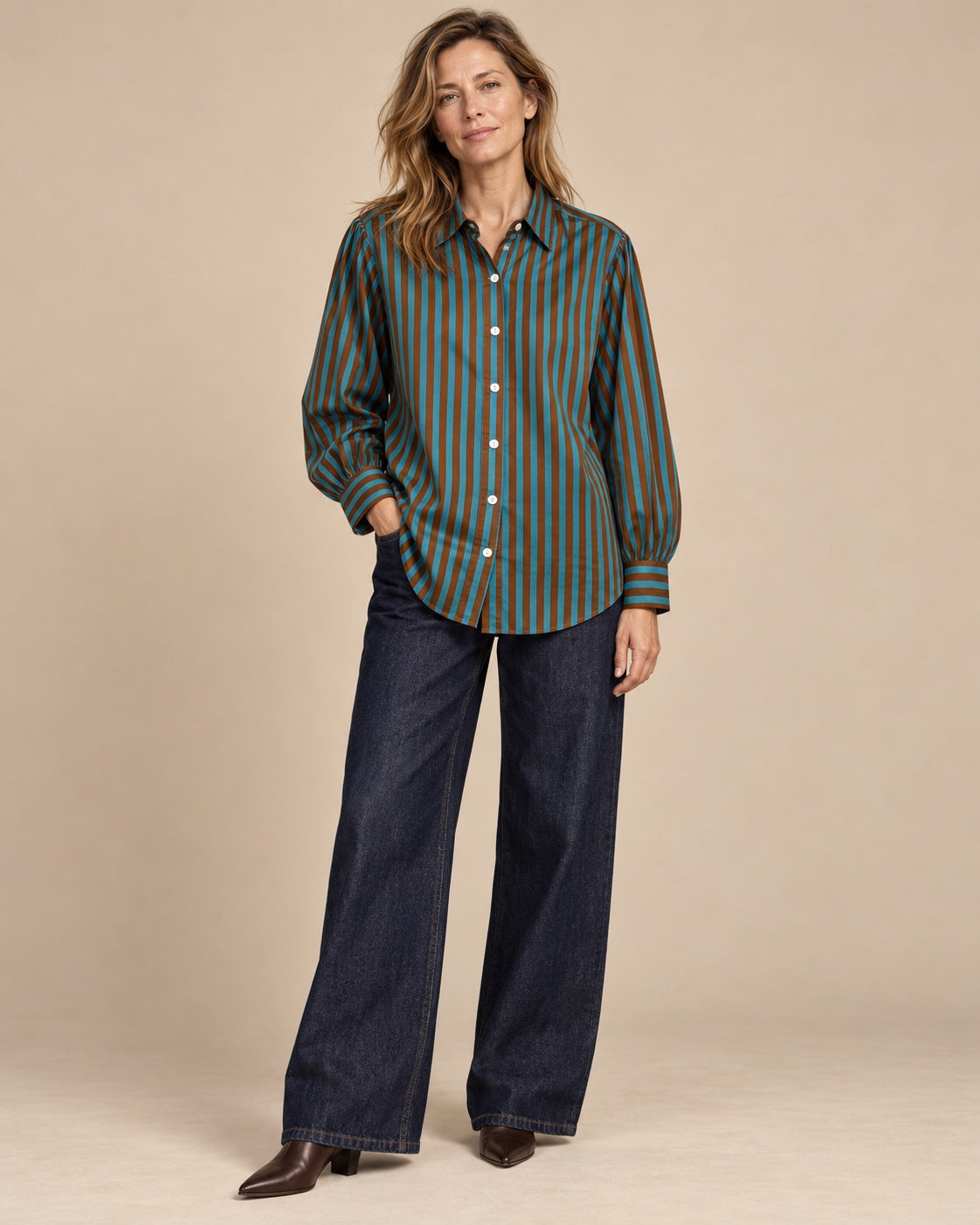 Model wearing turquoise and brown striped cotton shirt with wide dark jeans