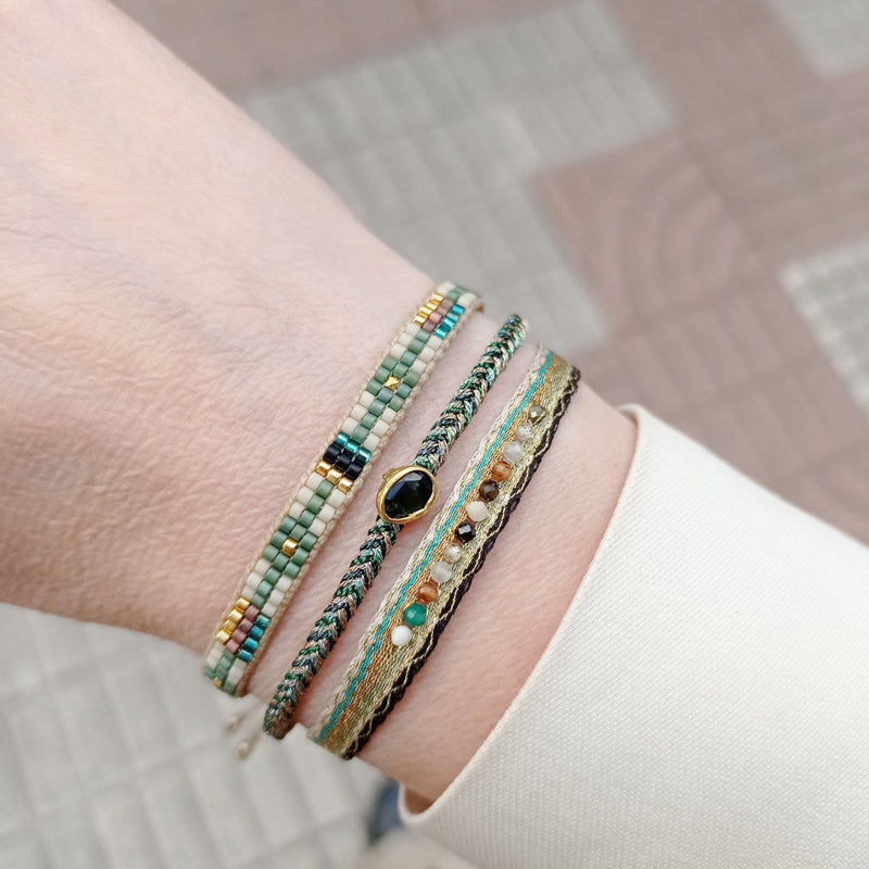 Delicate & feminine, this bracelet is handwoven using metallic gold and green threads and features a green onyx precious stone centrepiece. Onyx stones are symbols of happiness.  Wear it with your favourite accessories all season long, and with its adjustable pull cord you will always have the perfect fit!  Details:  - Onyx precious stone  - Vermeil setting   -Metallic threads  -Adjustable bracelet 