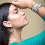 Delicate & feminine, this bracelet is handwoven using metallic gold and green threads and features a green onyx precious stone centrepiece. Onyx stones are symbols of happiness.  Wear it with your favourite accessories all season long, and with its adjustable pull cord you will always have the perfect fit!  Details:  - Onyx precious stone  - Vermeil setting   -Metallic threads  -Adjustable bracelet 