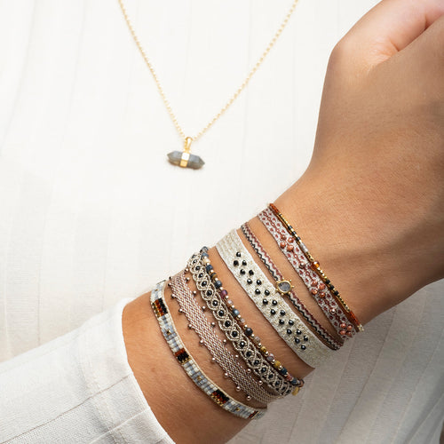   This beautiful hadmade bracelet has been handwoven in Colombia by our team of artisans using Polyester threads in burgundy tones with 14k rose gold filled beads.  This can be worn solo or with your favourite pieces.  Details:      Polyester threads     14k rose gold filled beads     Handwoven adjustable bracelet     Width 5mm     Can be worn in the water     Women bracelet