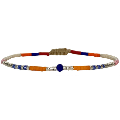   Handwoven in Colombia, this feminine bracelet features a single row of Japanese glass beads in gold and bright tones with a Lapis Lazuli stone of strenght and discipline in the centre.  Wear this stylish bracelet alone or as a part of a bracelet layering combination, with your favourite jeans & t-shirt!  Details:  - Japanese glass beads  - Silver faceted beads  -Lapis lazuli  - Width: 2mm  - Adjustable bracelet 