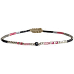Handwoven in Colombia, this delicate bracelet features a single row of Japanese glass beads in gold and neutral tones with a Spinel, stone of money and prosperity, in the centre.  Wear this stylish bracelet alone or as a part of a bracelet layering combination, with your favourite outfits.  Details:  - Japanese glass beads  - Gold vermeil faceted beads  - Spinel semi-precious stone  - Width: 2mm  -Can be worn in the water