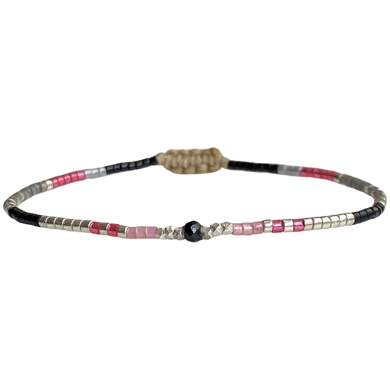 Handwoven in Colombia, this delicate bracelet features a single row of Japanese glass beads in gold and neutral tones with a Spinel, stone of money and prosperity, in the centre.  Wear this stylish bracelet alone or as a part of a bracelet layering combination, with your favourite outfits.  Details:  - Japanese glass beads  - Gold vermeil faceted beads  - Spinel semi-precious stone  - Width: 2mm  -Can be worn in the water