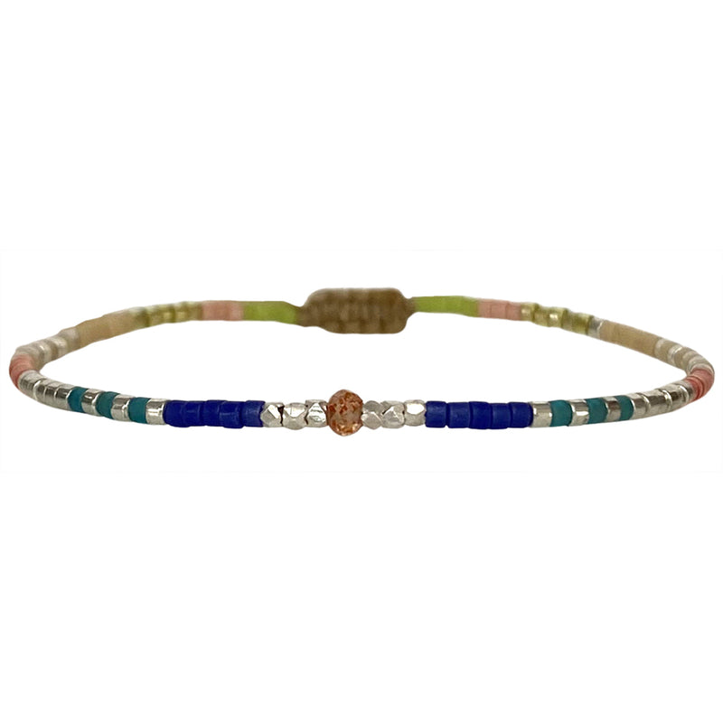   Handwoven in Colombia, this feminine bracelet features a single row of Japanese glass beads in gold and bright tones with a Peach sun-stone of strenght and discipline in the centre.  Wear this stylish bracelet alone or as a part of a bracelet layering combination, with your favourite jeans & t-shirt!  Details:  - Japanese glass beads  - Silver faceted beads  -Peach Sun stone  - Width: 2mm  - Adjustable bracelet 