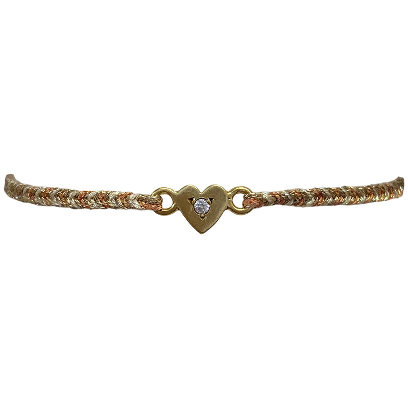 This delicate bracelet is handmade by our team of master artisans using metallic threads and a gold heart charm encrusted with a sparkling quartz stone. It's the perfect accessory to add a little sparkle in your life.  Details:      Quartz semi-precious stone     Gold Vermeil setting     Macramé weaving technique     Adjustable handwoven bracelet     Width 4mm