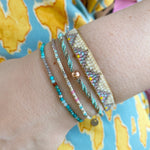 SET OF THREE HANDMADE BRACELETS WITH TURQOUISE THREADS AND MULTICOLORED BEADS ON MODEL