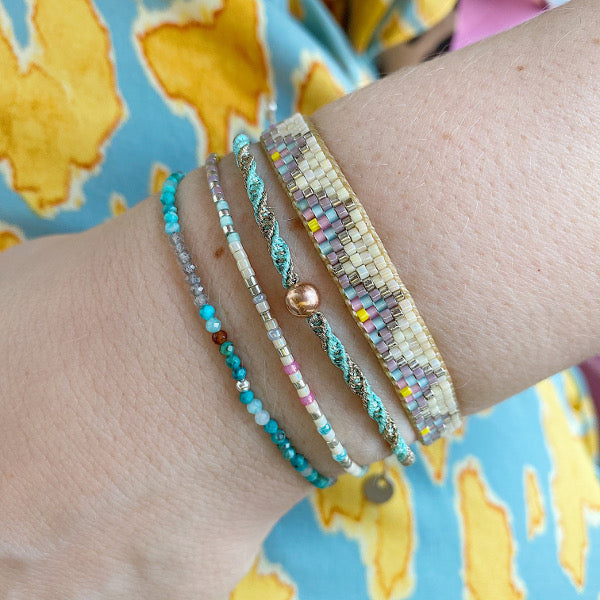 SET OF THREE HANDMADE BRACELETS WITH TURQOUISE THREADS AND MULTICOLORED BEADS ON MODEL