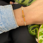 HANDWOVEN HEART BRACELET IN ORANGE AND GOLD
