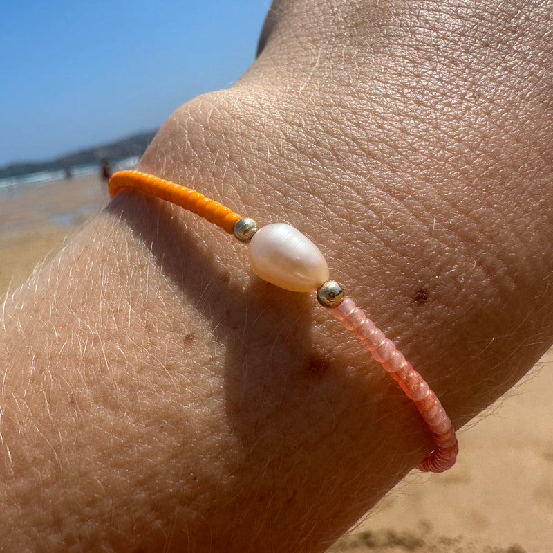 Make a confident statement with this beautiful handmade bracelet. This design is handwoven by our team of artisans using japanese glass beads,14k gold filled beads and a freshwater pearl.  This bracelet is elegant and femenine, making it the perfect accessory for any occasion.  Details  - Japanese glass beads   - 14 k gold filled beads  - Adjustable Bracelet  -Width: 2mm  -Can be worn in the  water