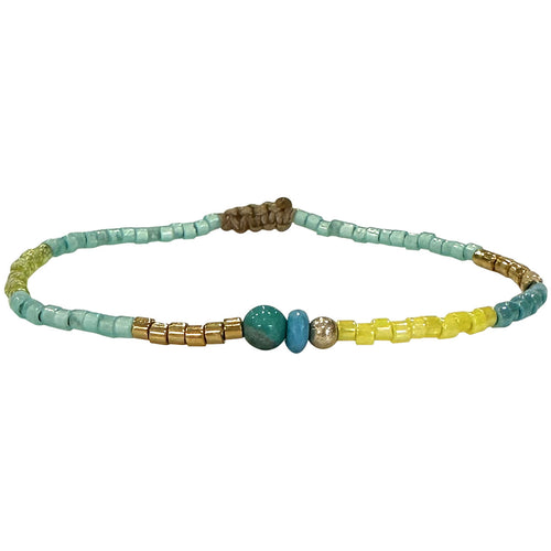 Handwoven in Colombia, this delicate bracelet features a single row of Japanese glass beads, 14 k gold filled bead and a turquoise stone.  Wear this stylish bracelet alone or as a part of a bracelet layering combination, with your favourite outfits.  Details:  - Japanese glass beads  - 14 k Gold filled bead  - Turquoise  semi-precious stone  - Width: 2mm  -Can be worn in the water