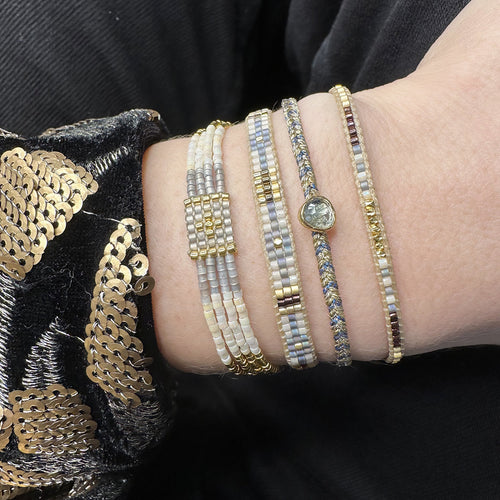 Handwoven in Colombia, this feminine bracelet features a single row of Japanese glass beads in gold and brown tones and gold faceted beads  Wear this stylish bracelet alone or as a part of a bracelet layering combination, with your favourite jeans & t-shirt!  Details:  -Gold faceted beads  - Japanese glass beads  - Width: 2mm  - Adjustable bracelet 