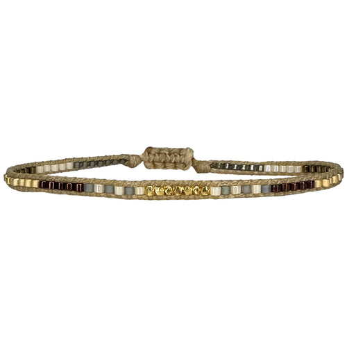 Handwoven in Colombia, this feminine bracelet features a single row of Japanese glass beads in gold and brown tones and gold faceted beads  Wear this stylish bracelet alone or as a part of a bracelet layering combination, with your favourite jeans & t-shirt!  Details:  -Gold faceted beads  - Japanese glass beads  - Width: 2mm  - Adjustable bracelet 
